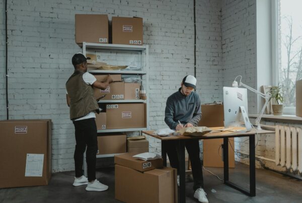 Two men standing next to boxes